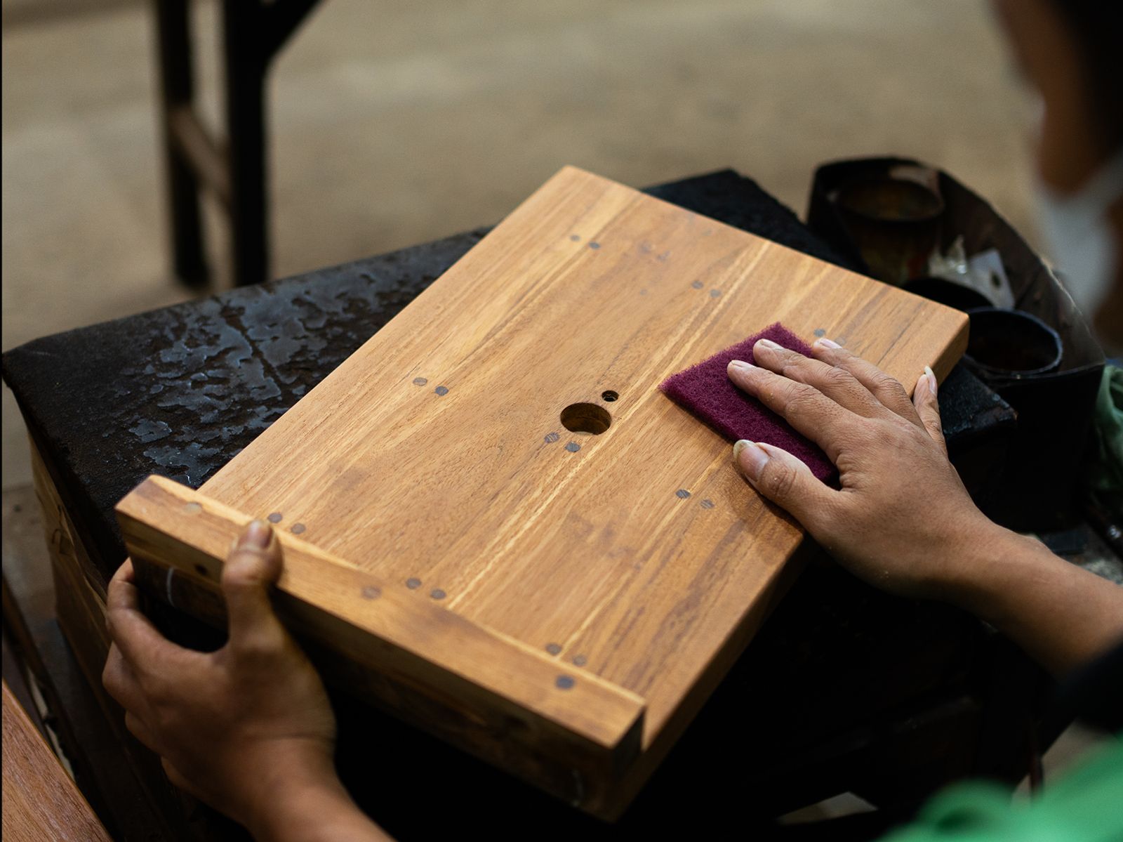 A Man sanding wood by hand